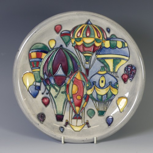 A Moorcroft 'Balloon' pattern Plate, with tube lined decoration on grey ground, of second quality, with factory marks to base, dated 99, 26cm diameter.