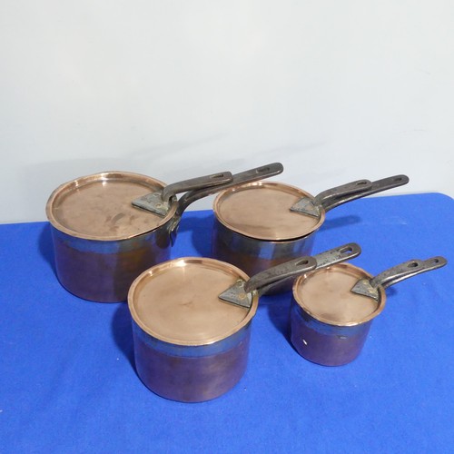 368 - A set of four graduated 19thC copper Saucepans, each graduating in size, with cast iron handles and ... 