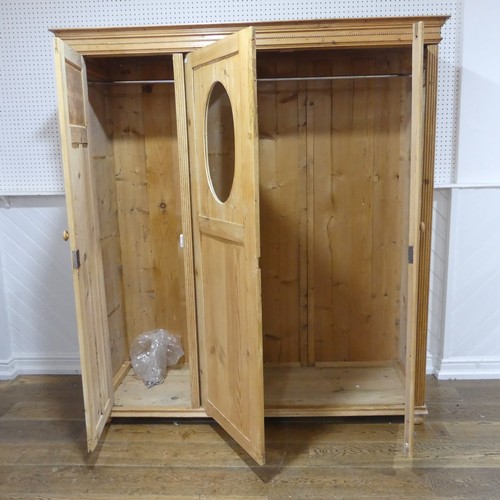 380 - A Victorian pine Wardrobe, with bead moulded cornice above three panelled doors, with central mirror... 