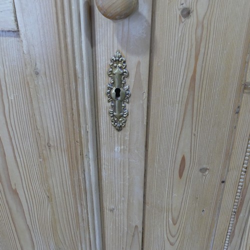 380 - A Victorian pine Wardrobe, with bead moulded cornice above three panelled doors, with central mirror... 