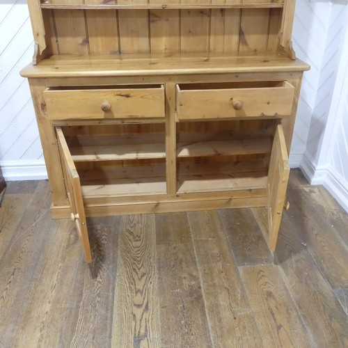 383 - An antique pine kitchen Dresser, with moulded cornice above a three tier plate rack, with two drawer... 