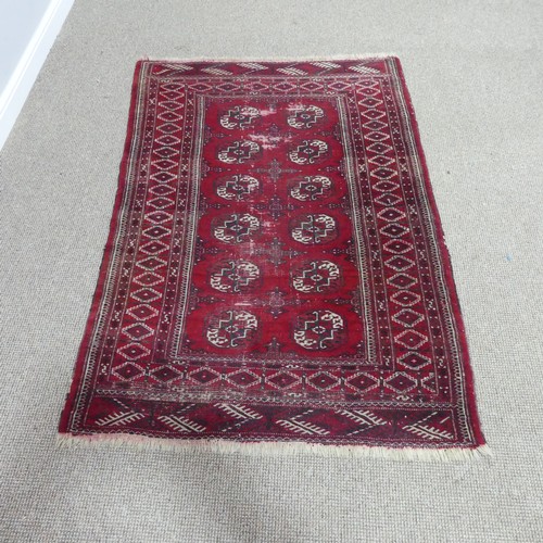 285 - Tribal rugs; a red ground Bokhara rug, worn,  176cm x 118cm.