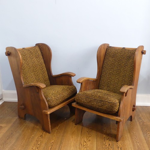 401 - A pair of Arts & Crafts elm 'Lambing Chairs', with shaped back and arm rests, raised upon shaped... 