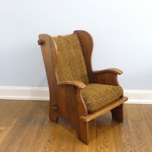 401 - A pair of Arts & Crafts elm 'Lambing Chairs', with shaped back and arm rests, raised upon shaped... 