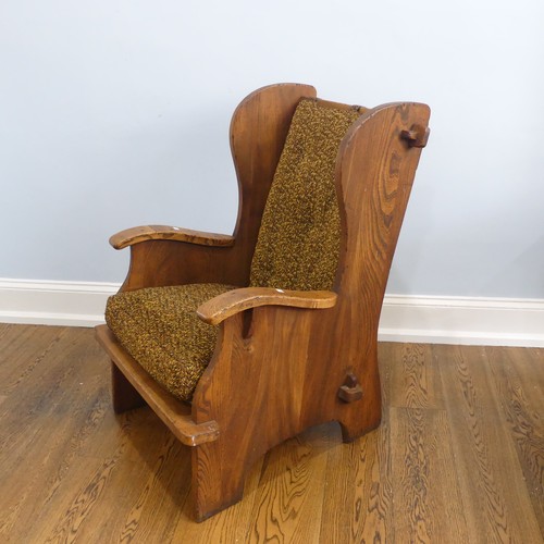 401 - A pair of Arts & Crafts elm 'Lambing Chairs', with shaped back and arm rests, raised upon shaped... 