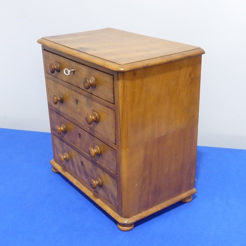 408 - An antique miniature Chest of Drawers, comprising four long drawers, raised on bun feet, some woodwo... 