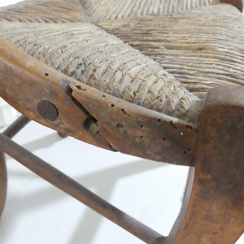 441 - A 20thC  rush seated child's Chair, with shaped back and rush seat supported on stretchers, split to... 