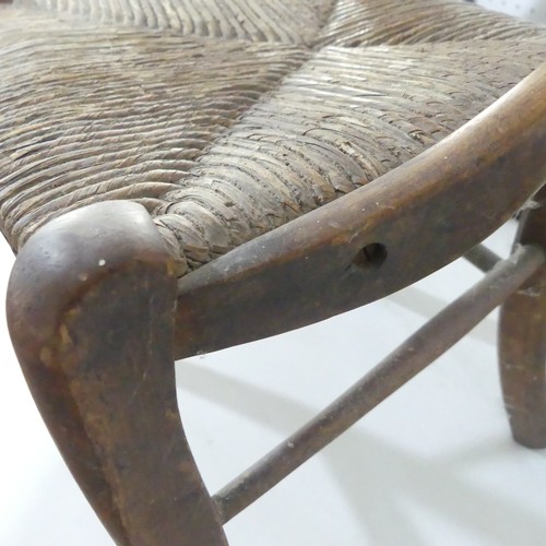 441 - A 20thC  rush seated child's Chair, with shaped back and rush seat supported on stretchers, split to... 