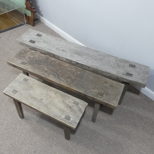 460 - A set of three rustic oak Benches, of graduating  size on splayed legs, one carved with initials HB ... 