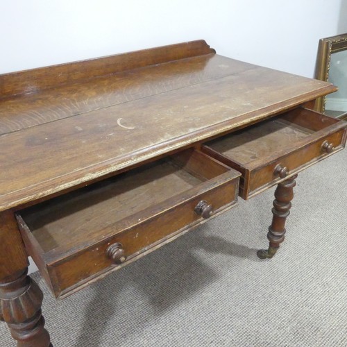 461 - An antique carved oak Writing table, with gallery back above two frieze drawers, all raised on turne... 