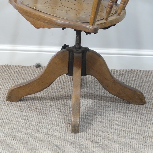 473 - A late 19thC/ early 20thC oak bow-arm swivel Desk Chair, the mechanism stamped Patt Apr 1895, damage... 