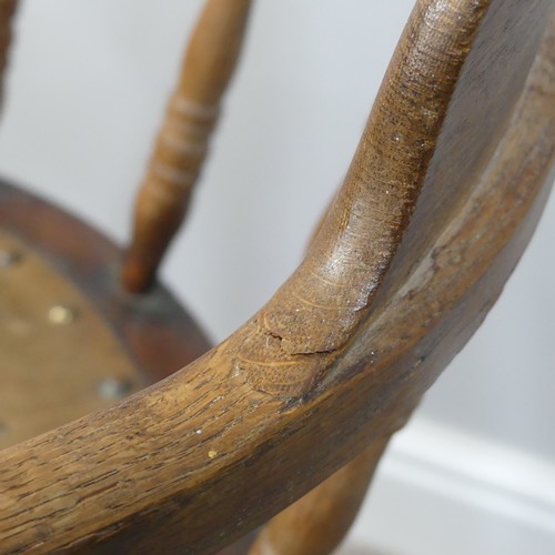 473 - A late 19thC/ early 20thC oak bow-arm swivel Desk Chair, the mechanism stamped Patt Apr 1895, damage... 