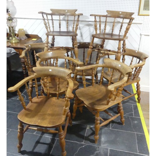 534 - A set of eight elm and beech Smokers Bow Chairs, with turned spindles, shaped seat and H stretcher (... 