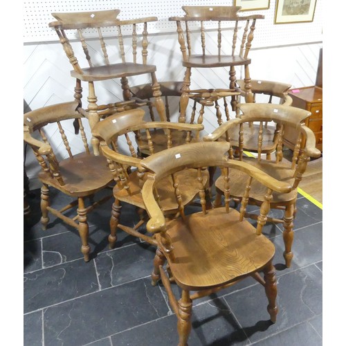 534 - A set of eight elm and beech Smokers Bow Chairs, with turned spindles, shaped seat and H stretcher (... 