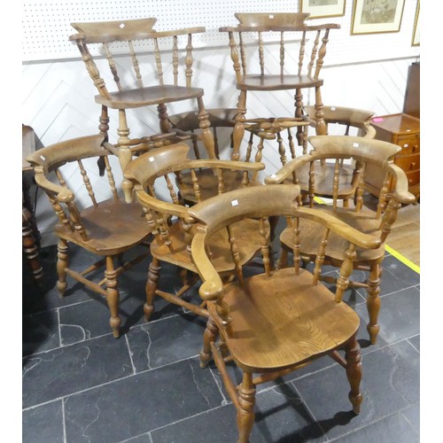 534 - A set of eight elm and beech Smokers Bow Chairs, with turned spindles, shaped seat and H stretcher (... 