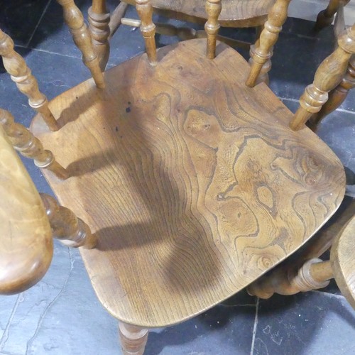 534 - A set of eight elm and beech Smokers Bow Chairs, with turned spindles, shaped seat and H stretcher (... 