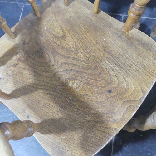 534 - A set of eight elm and beech Smokers Bow Chairs, with turned spindles, shaped seat and H stretcher (... 