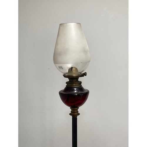 362 - A wrought iron and red glass standard Lamp Stand with Oil Lamp, the red glass lamp with opaque glass... 