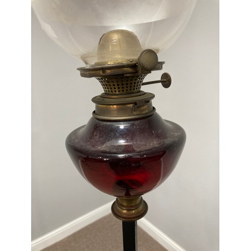 362 - A wrought iron and red glass standard Lamp Stand with Oil Lamp, the red glass lamp with opaque glass... 