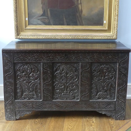 552 - A 17thC carved oak Coffer, the hinged lid opening to a spacious interior, above a three panel front ... 