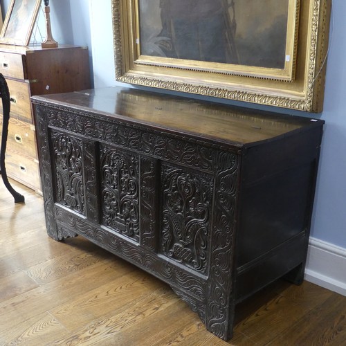 552 - A 17thC carved oak Coffer, the hinged lid opening to a spacious interior, above a three panel front ... 