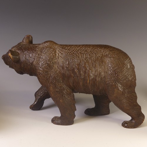 560 - An early 19thC Black Forest carved wooden Strolling Bear, naturistically carved with glass eyes, L 4... 