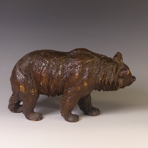 560 - An early 19thC Black Forest carved wooden Strolling Bear, naturistically carved with glass eyes, L 4... 