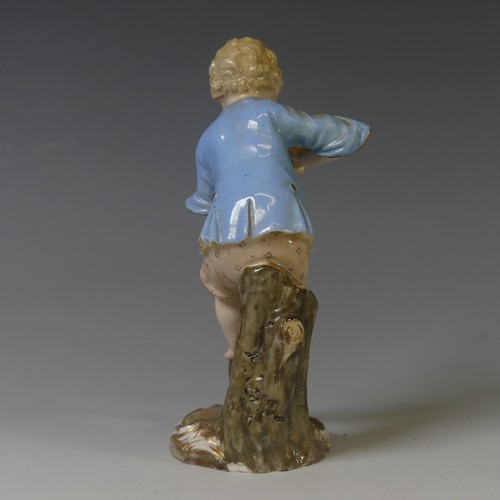 112 - A 19thC Meissen porcelain figure of a Young Gardener, the boy modelled digging with a spade, on oval... 