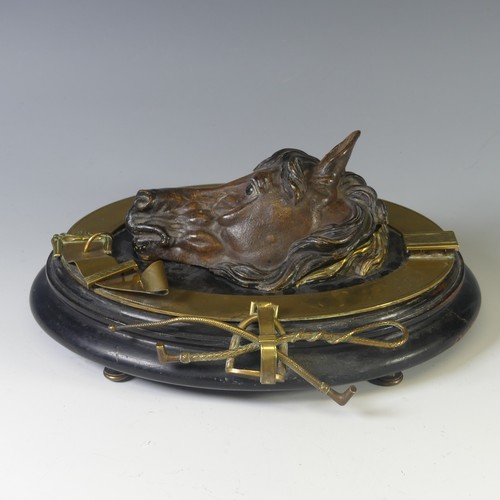 An Edwardian 'horse head' Ink Stand, the horse head opening to reveal a recess for an inkwell, with brass mounts, raised on an oval ebonised base with brass bun feet, W 29cm x D 23cm x H 11cm, together with a copper Coaching Horn stamped 'Royal Mail', 117cm long (2)