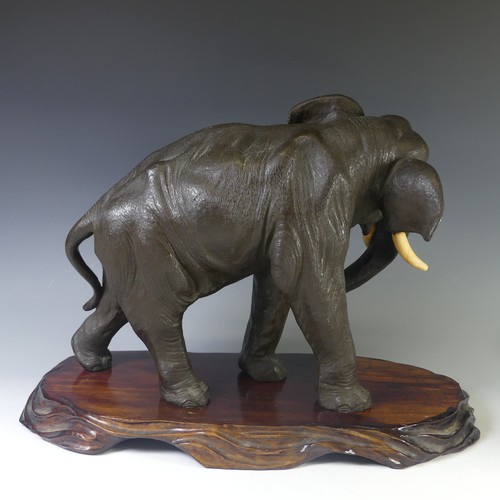 244 - A 19thC Japanese cast bronze figure of an Elephant, cast marching on four feet, head slightly turned... 