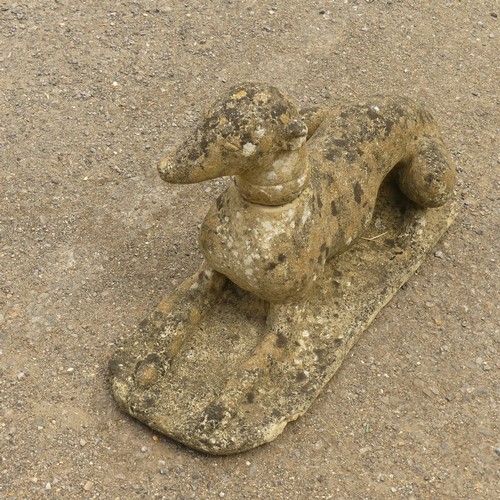 278 - Garden Statuary; A vintage reconstituted stone Dog, modelled laying on front legs, L 66cm x W 27cm x... 