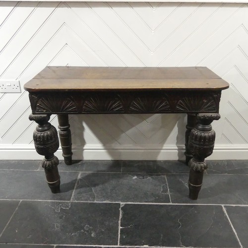 539 - A Victorian oak Console Table, the D shaped top upon a carved frieze, raised on carved and turned le... 