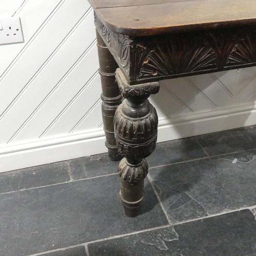 539 - A Victorian oak Console Table, the D shaped top upon a carved frieze, raised on carved and turned le... 