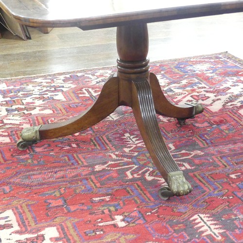 514 - A Georgian mahogany tilt-top Dining Table, the rounded rectangular top with inlaid arrows to corners... 