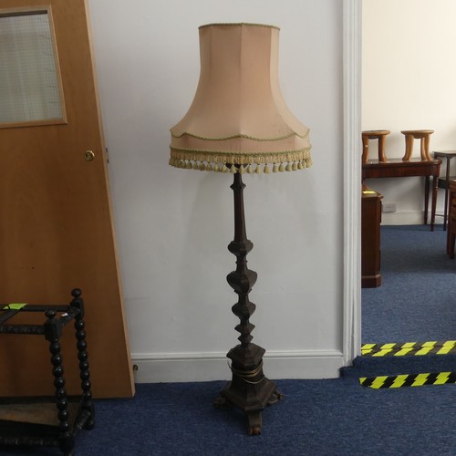 323 - An early 20thC continental carved walnut Standard Lamp, with triangular shaped balusters, raised on ... 