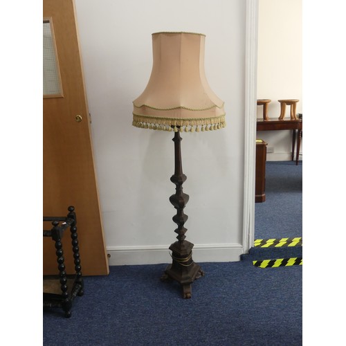 323 - An early 20thC continental carved walnut Standard Lamp, with triangular shaped balusters, raised on ... 