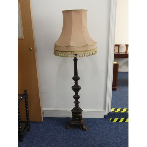 323 - An early 20thC continental carved walnut Standard Lamp, with triangular shaped balusters, raised on ... 