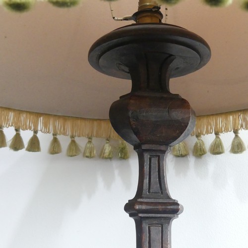 323 - An early 20thC continental carved walnut Standard Lamp, with triangular shaped balusters, raised on ... 