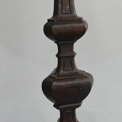 323 - An early 20thC continental carved walnut Standard Lamp, with triangular shaped balusters, raised on ... 