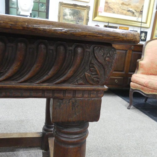 463 - An antique oak Refectory Table, the rectangular top raised above a carved frieze, all raised upon tu... 