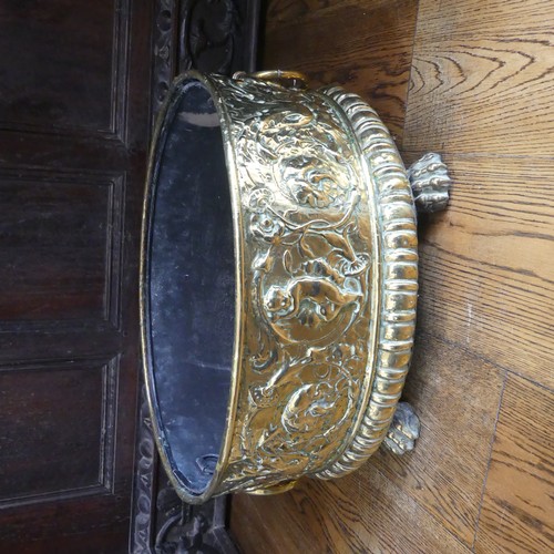 555 - An antique brass Wine Cooler, with embossed decoration of cherubs and leaves, metal lining, brass ca... 