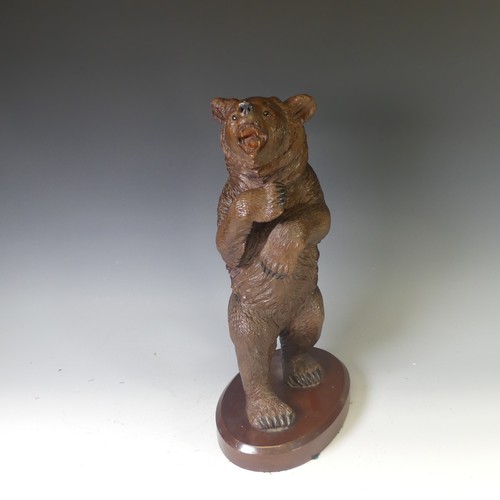 551 - An early 20thC Black Forest carved wooden Standing Bear, naturistically carved with glass eyes, moun... 