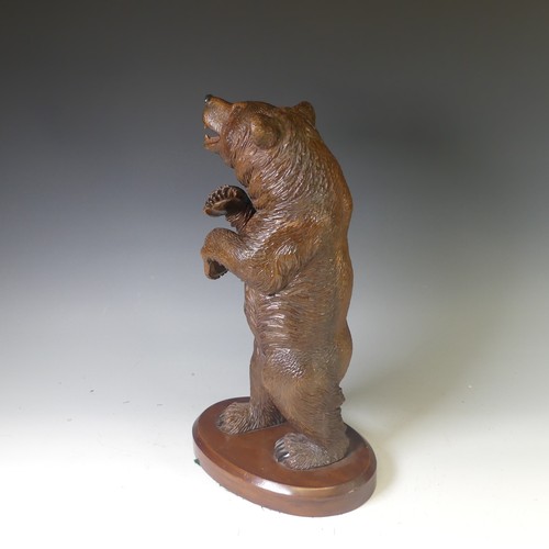 551 - An early 20thC Black Forest carved wooden Standing Bear, naturistically carved with glass eyes, moun... 