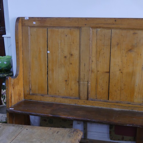 474 - A large antique pine Settle, with panelled back and scrolling end supports, base under the seat need... 