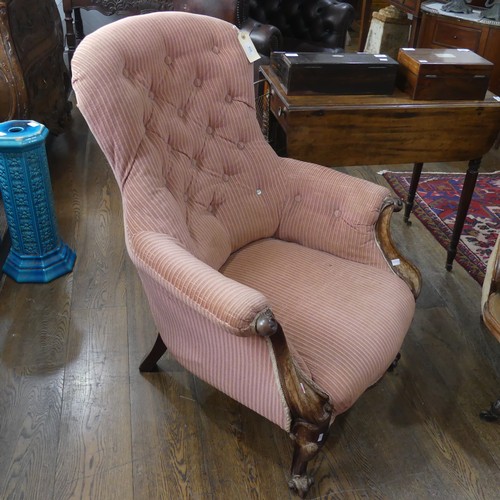 519 - A Victorian button-back Armchair, with a shaped back and armrests, on shaped feet, some fading and d... 