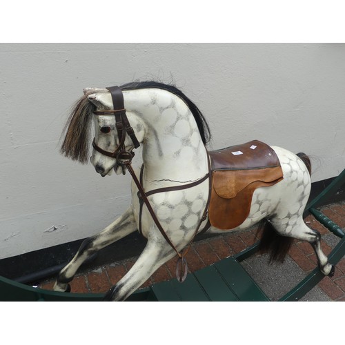 507 - An early 20thC grey dapple painted Rocking Horse, with mane, leather saddle and tack, on wooden rock... 