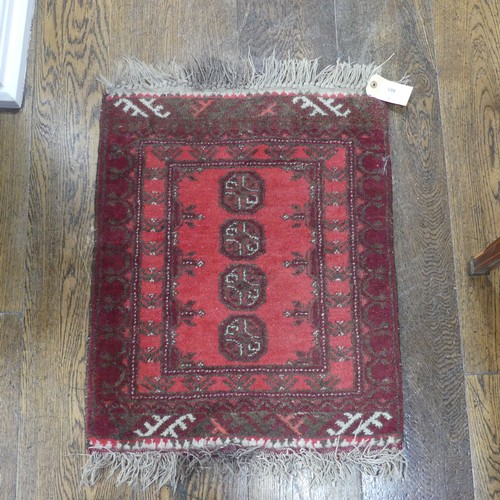 601 - Tribal rugs; a small red ground wool Afghan Mat, together with a machine made hanging (2)... 