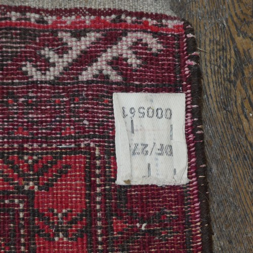 601 - Tribal rugs; a small red ground wool Afghan Mat, together with a machine made hanging (2)... 