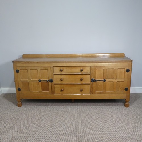 Robert 'Mouseman' Thompson (Kilburn); an English oak Sideboard, with raised upstand, above two doors enclosing three graduating drawers (one fitted for cutlery), turned handles, wrought iron hinges and latches, on four octagonal block feet, W 182cm x D 47cm x H 82cm.