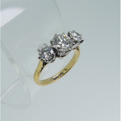 A three stone diamond Ring, the centre circular stone c. 0.95ct, with a smaller stone on each shoulder, each approx 0.35ct, all mounted in 18ct yellow gold and platinum, Size L, approx total weight 4.3g.